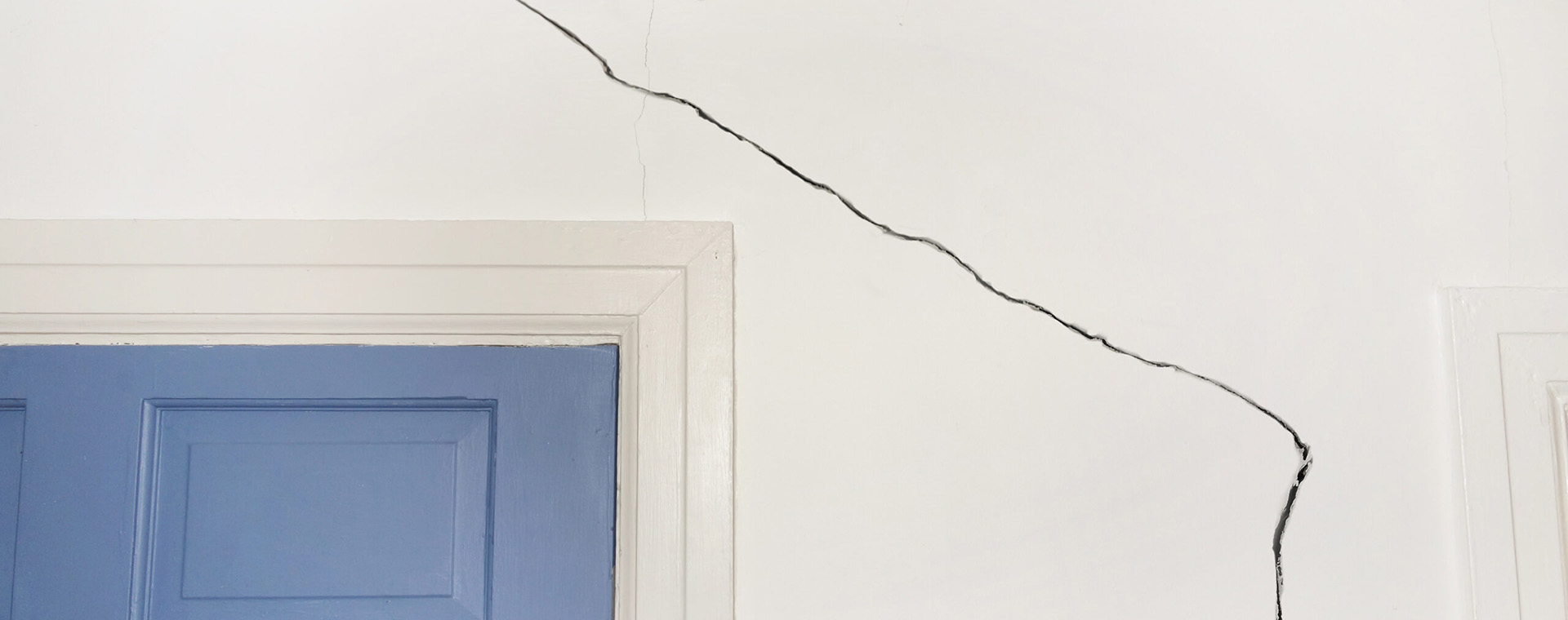 Vertikaler Riss an der Wand eines Einfamilienhauses, der auf ein strukturelles Problem hinweist