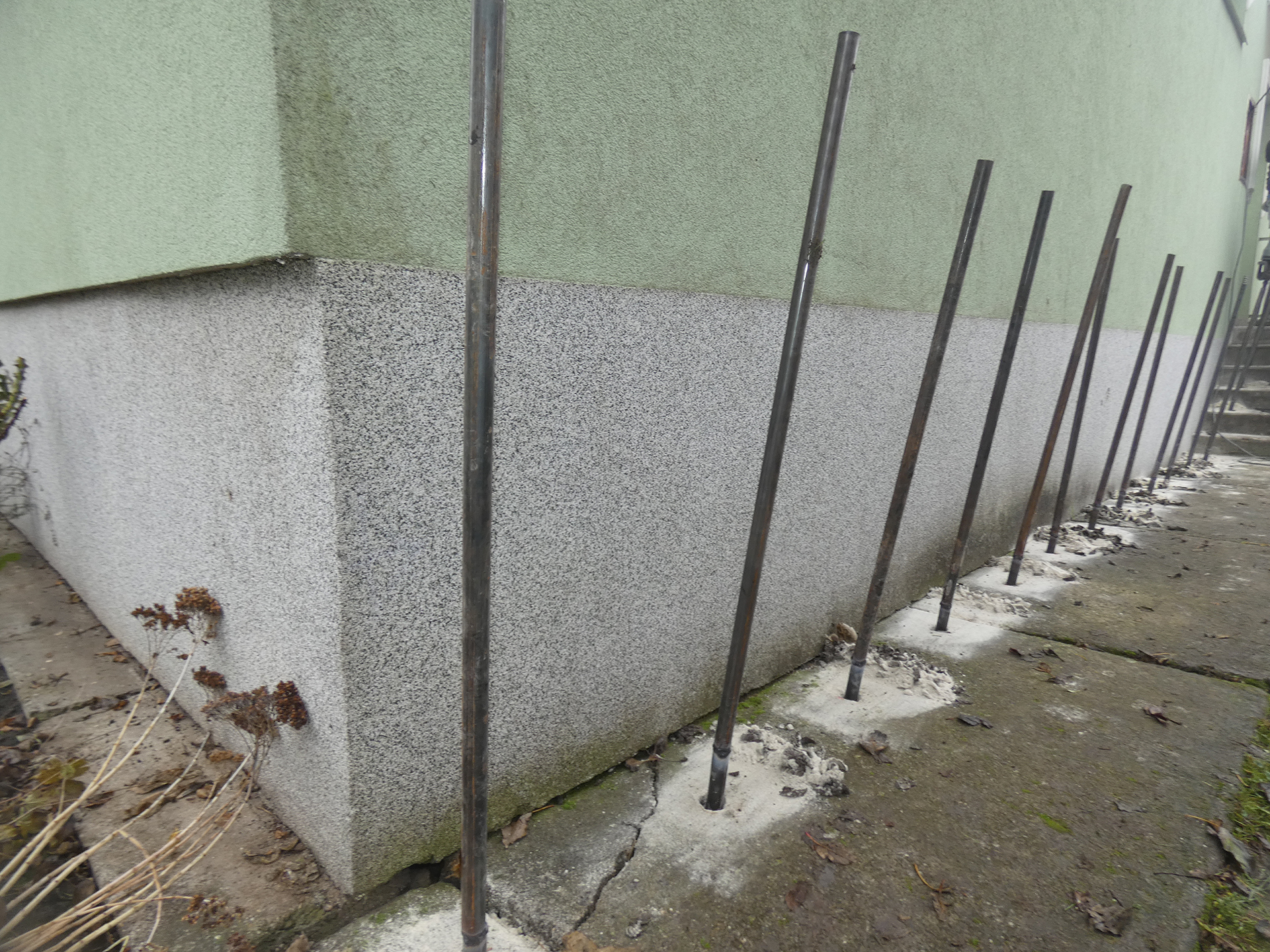 Stabilisierung eines Gebäudes durch Injektion – Bohrlöcher und Materialeinpressung unter dem Fundament eines Einfamilienhauses